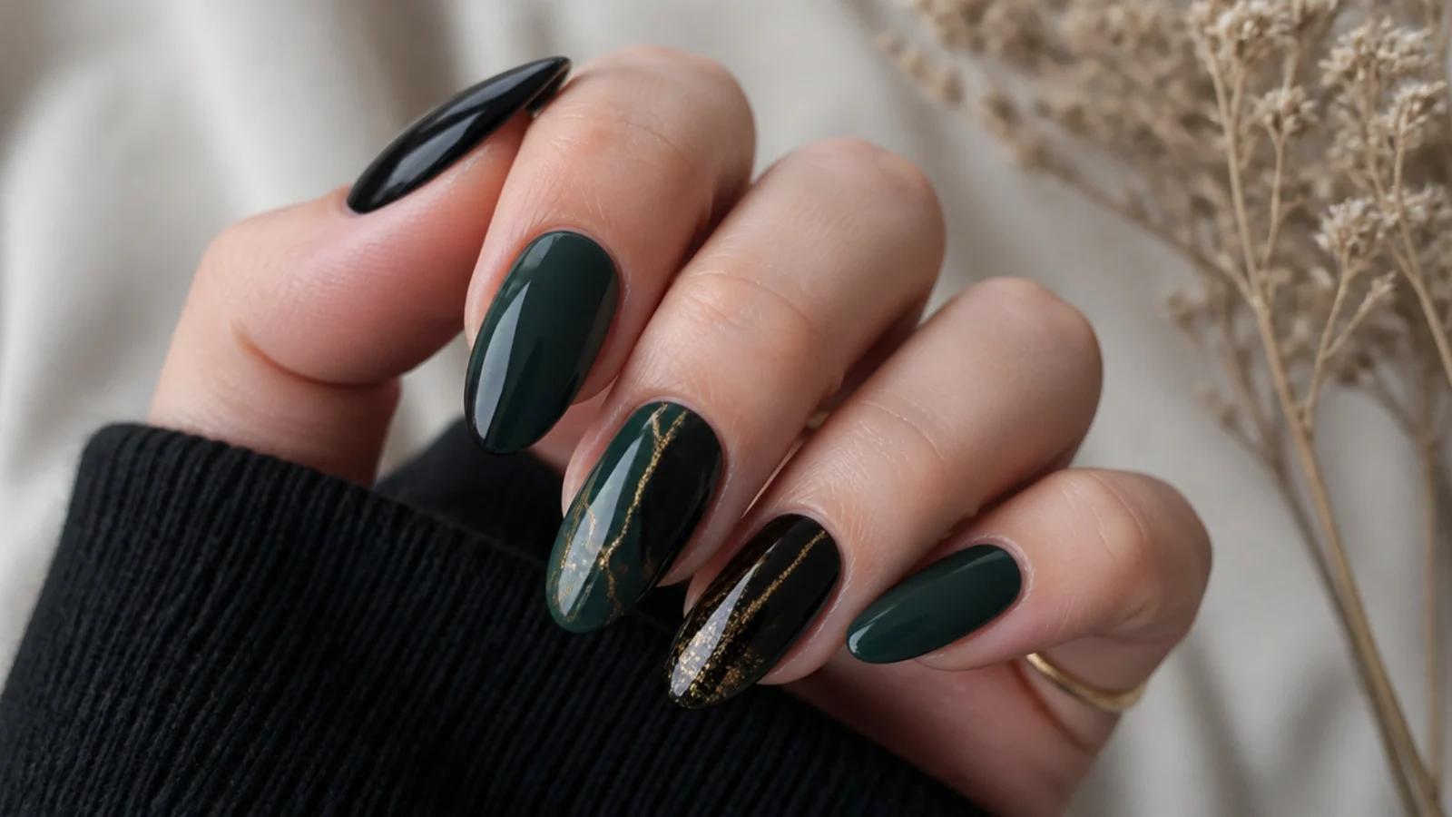 Dark emerald green and glossy black nails on an almond shape