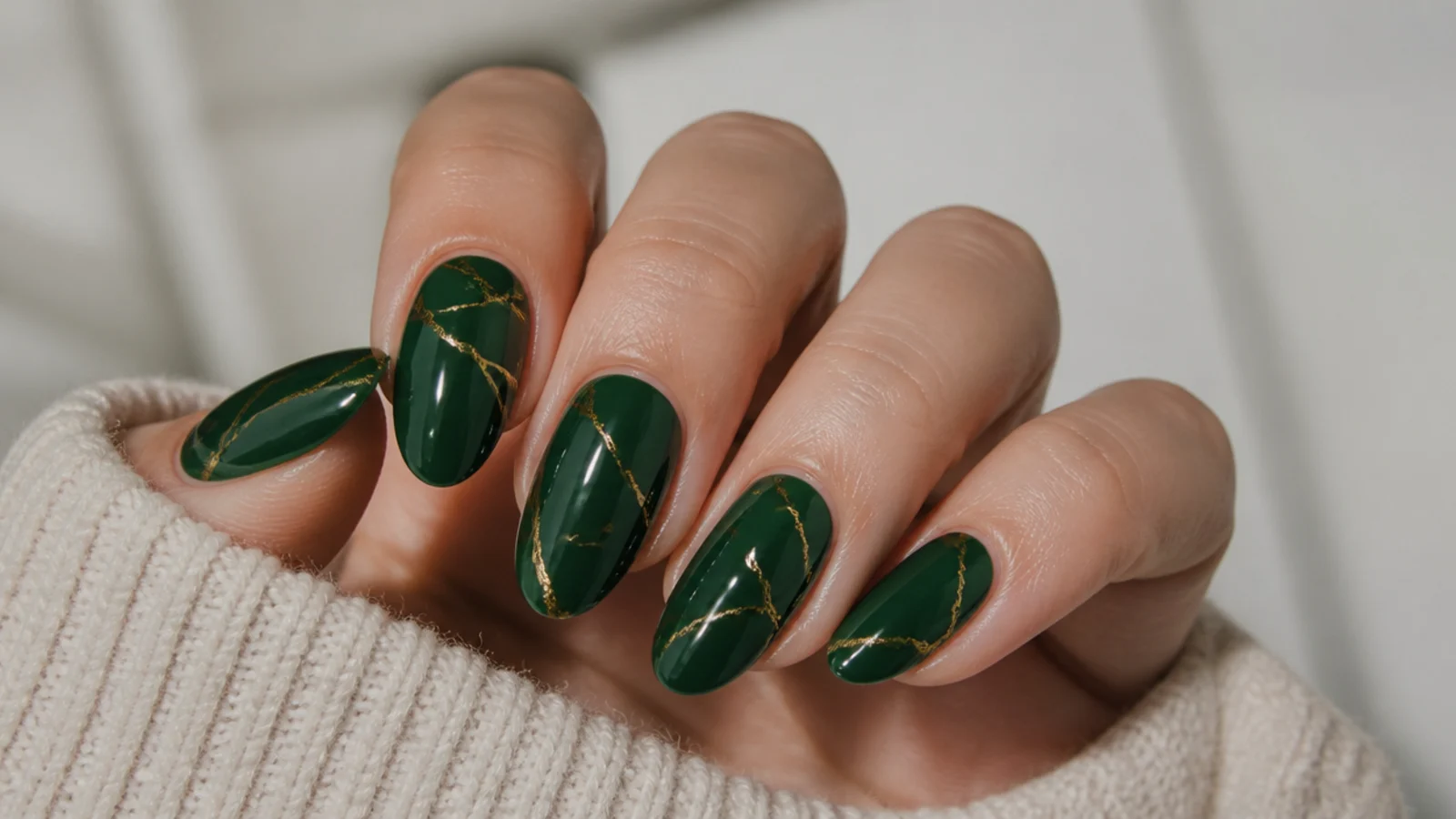 Deep forest green nails with fine hand-drawn gold vein lines