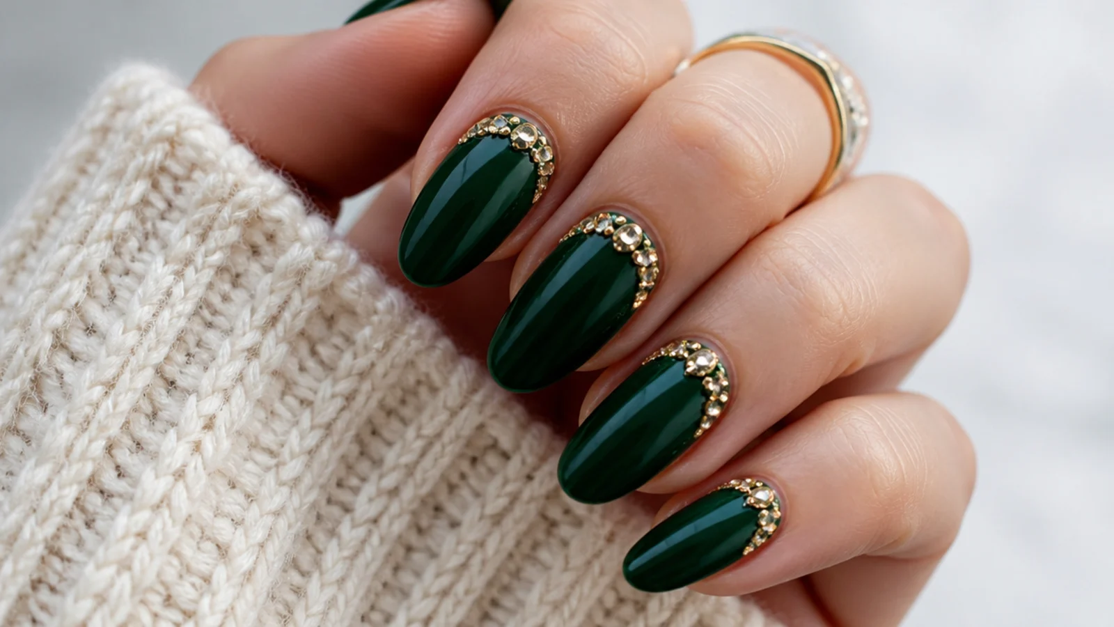 Emerald green nails with a cluster of gold rhinestones near the cuticle