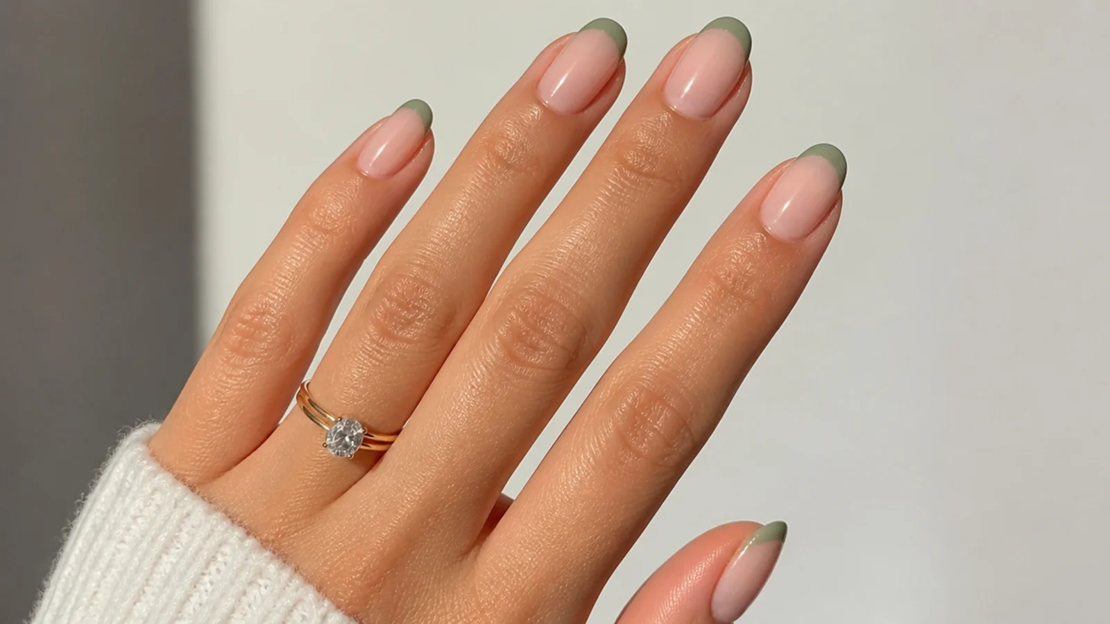 Sheer nude nails with muted sage-green micro french tips