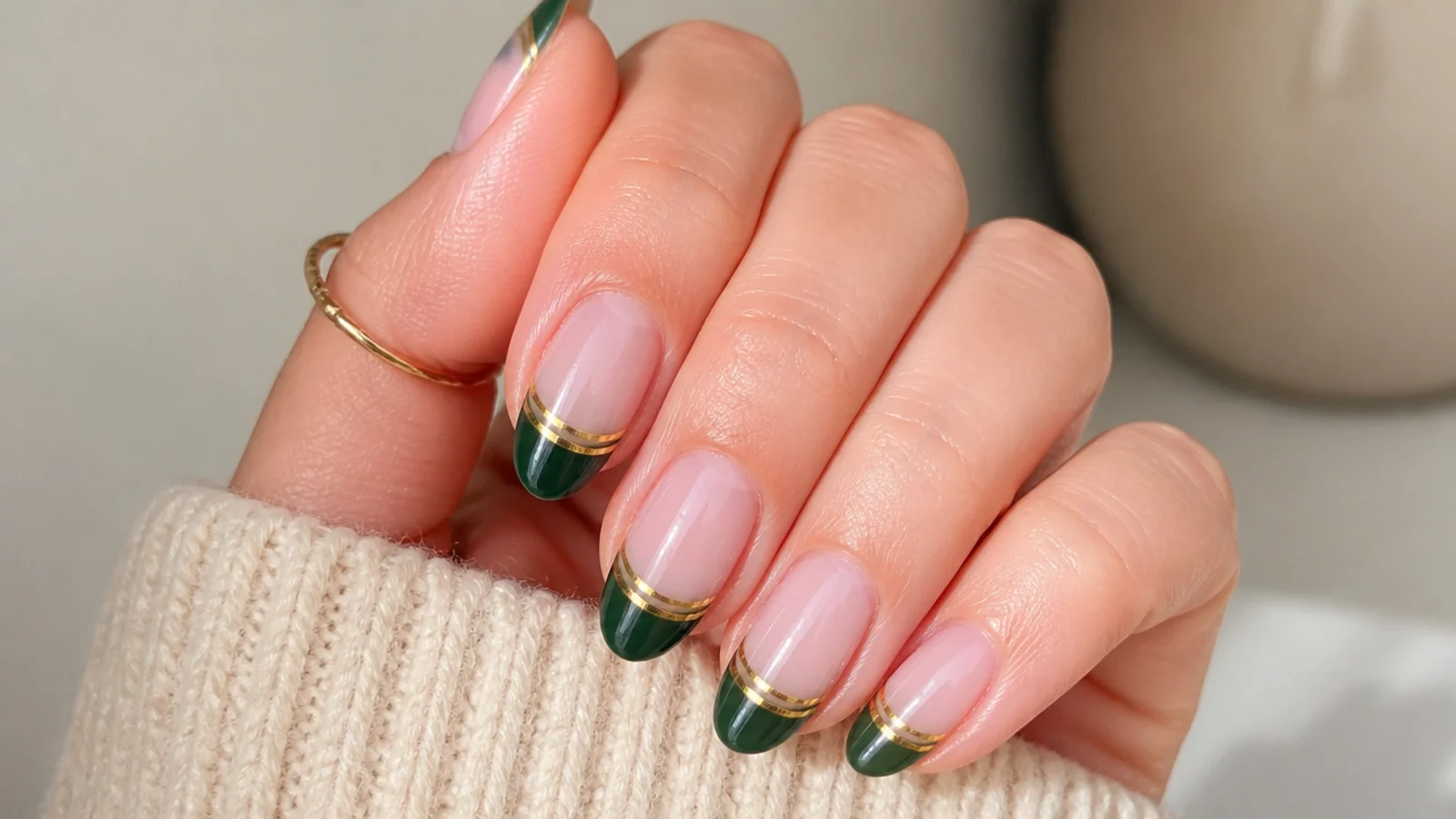 Sheer nails with dark green french tips and a double gold underline