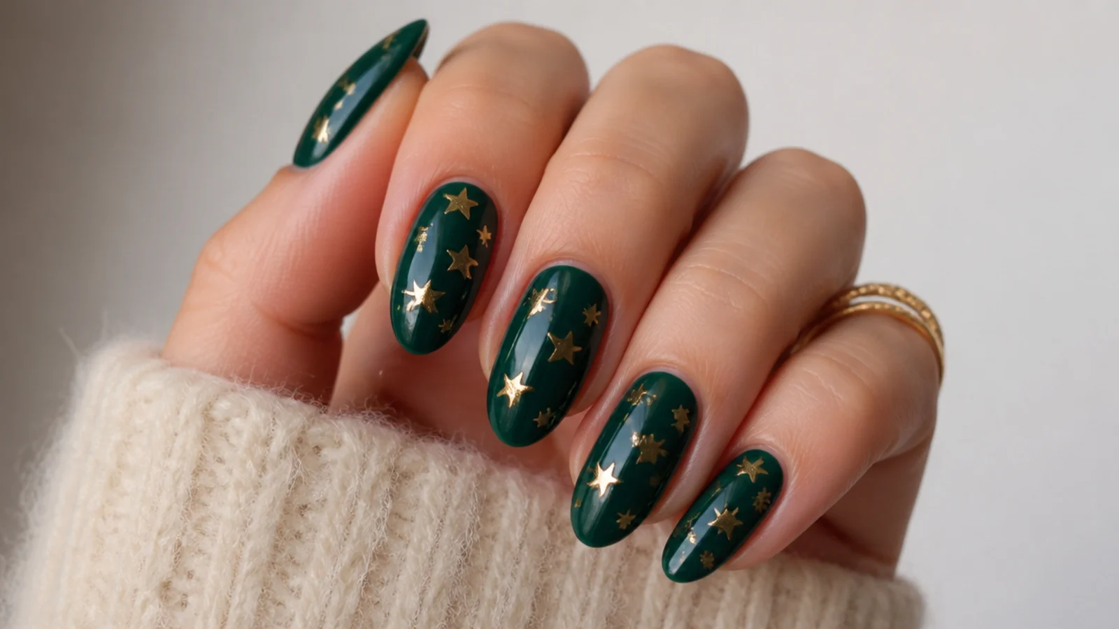 Emerald green nails with scattered small gold stars