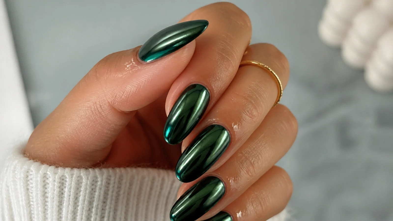 A well-sealed dark green chrome manicure with cuticle oil for longevity