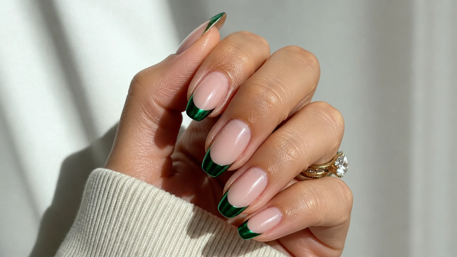 Mirror chrome emerald green french tip nails on a nude base