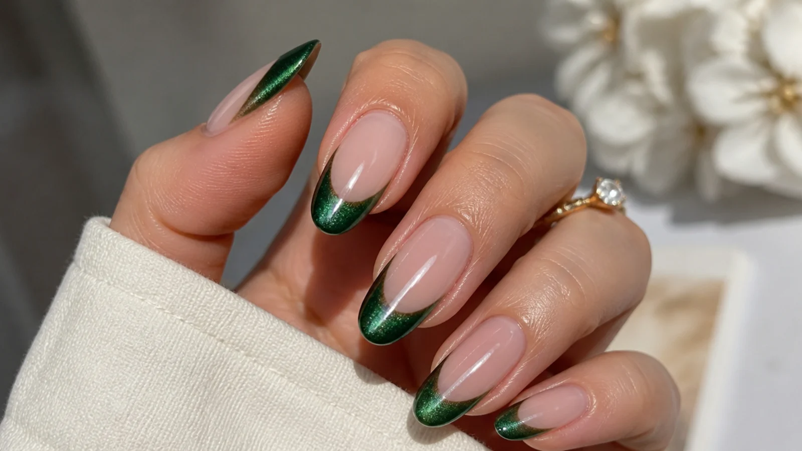 Soft velvet magnetic emerald green french tip nails with a cat-eye sheen