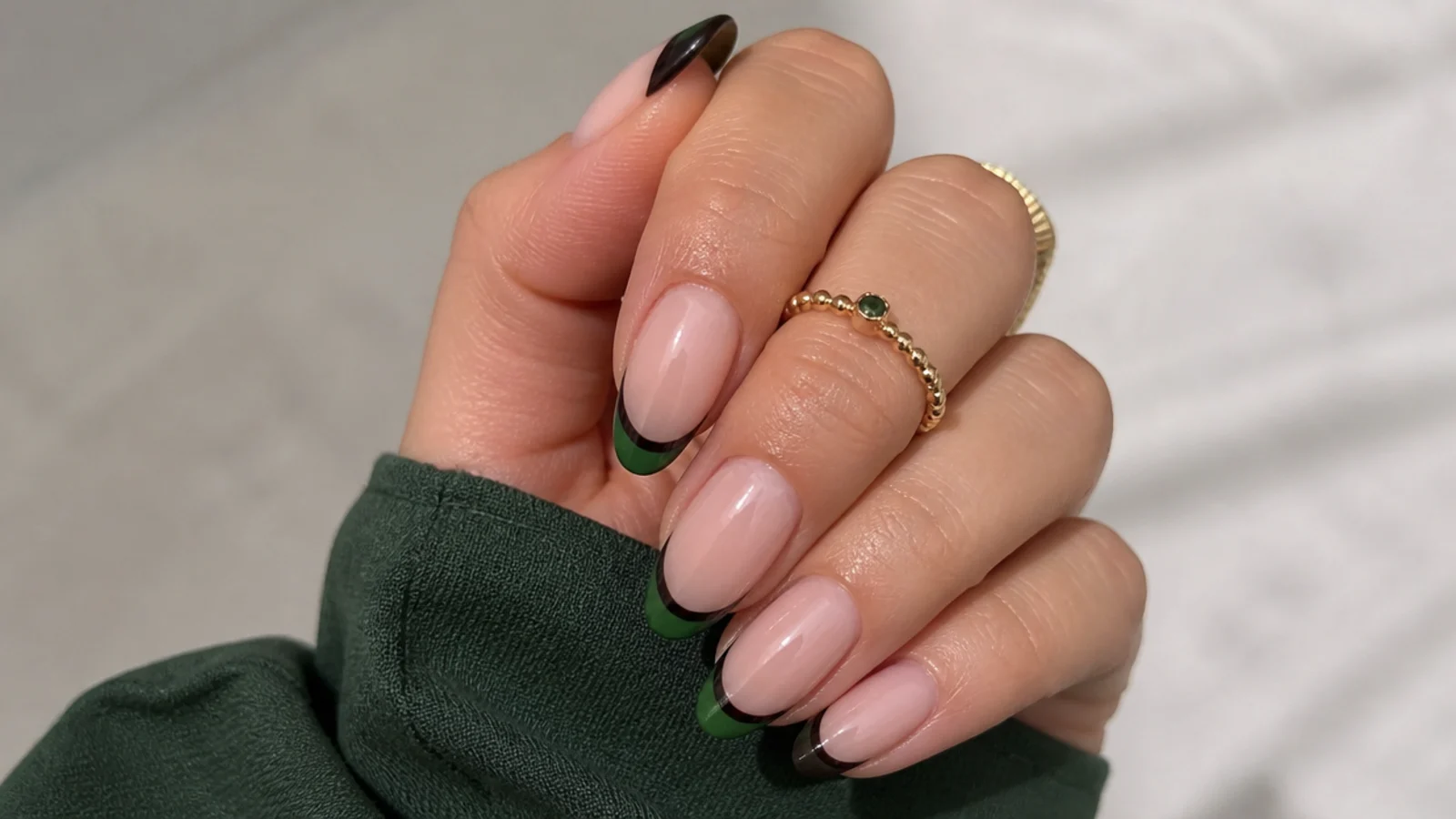 Layered forest green and black double french tip nails on a nude base