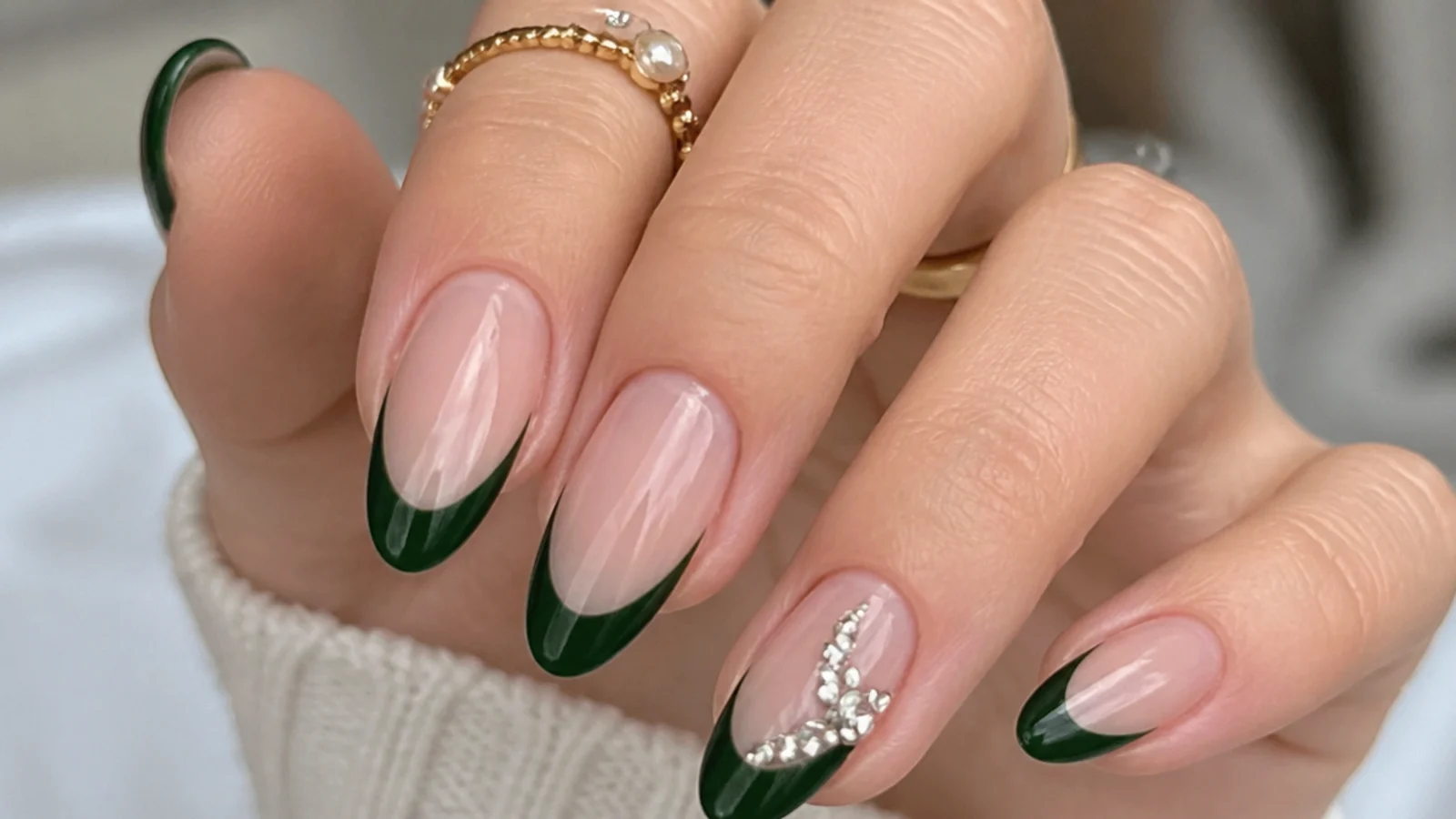 Emerald green french tips with a cluster of small rhinestones on one accent nail