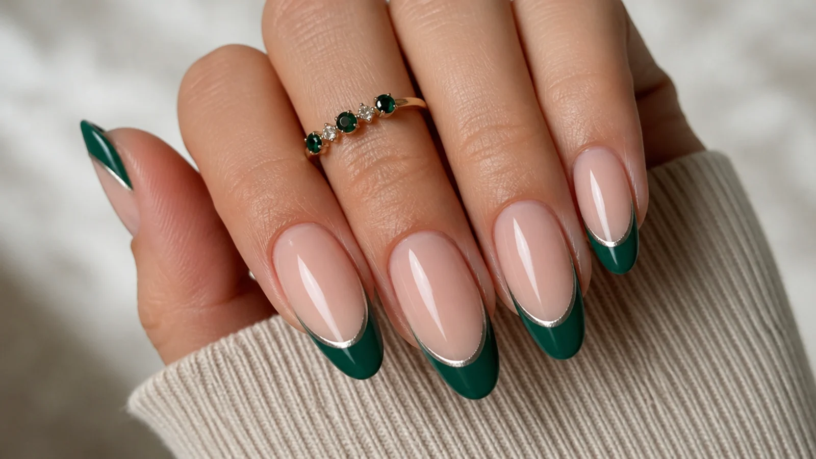 Emerald green french tips outlined with a thin silver chrome line on nude nails