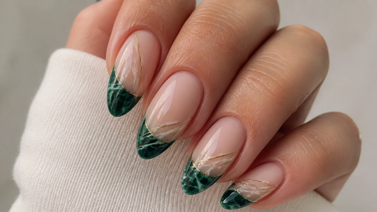 Emerald green french tips with soft white and gold marble veining on nude nails