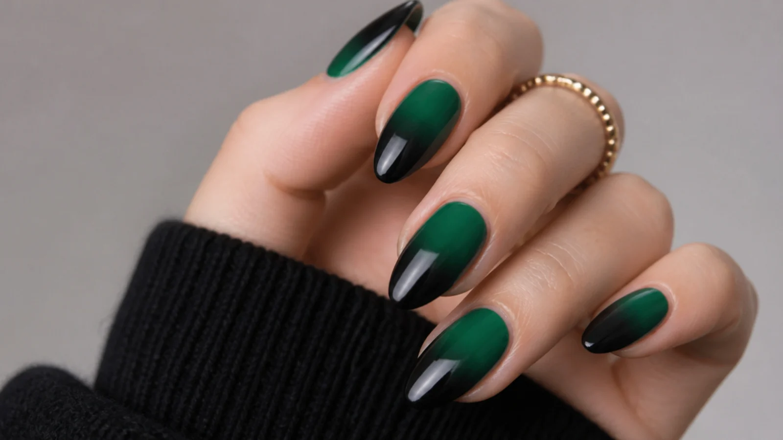 Ombre nails fading from emerald green at the cuticle to black at the tip