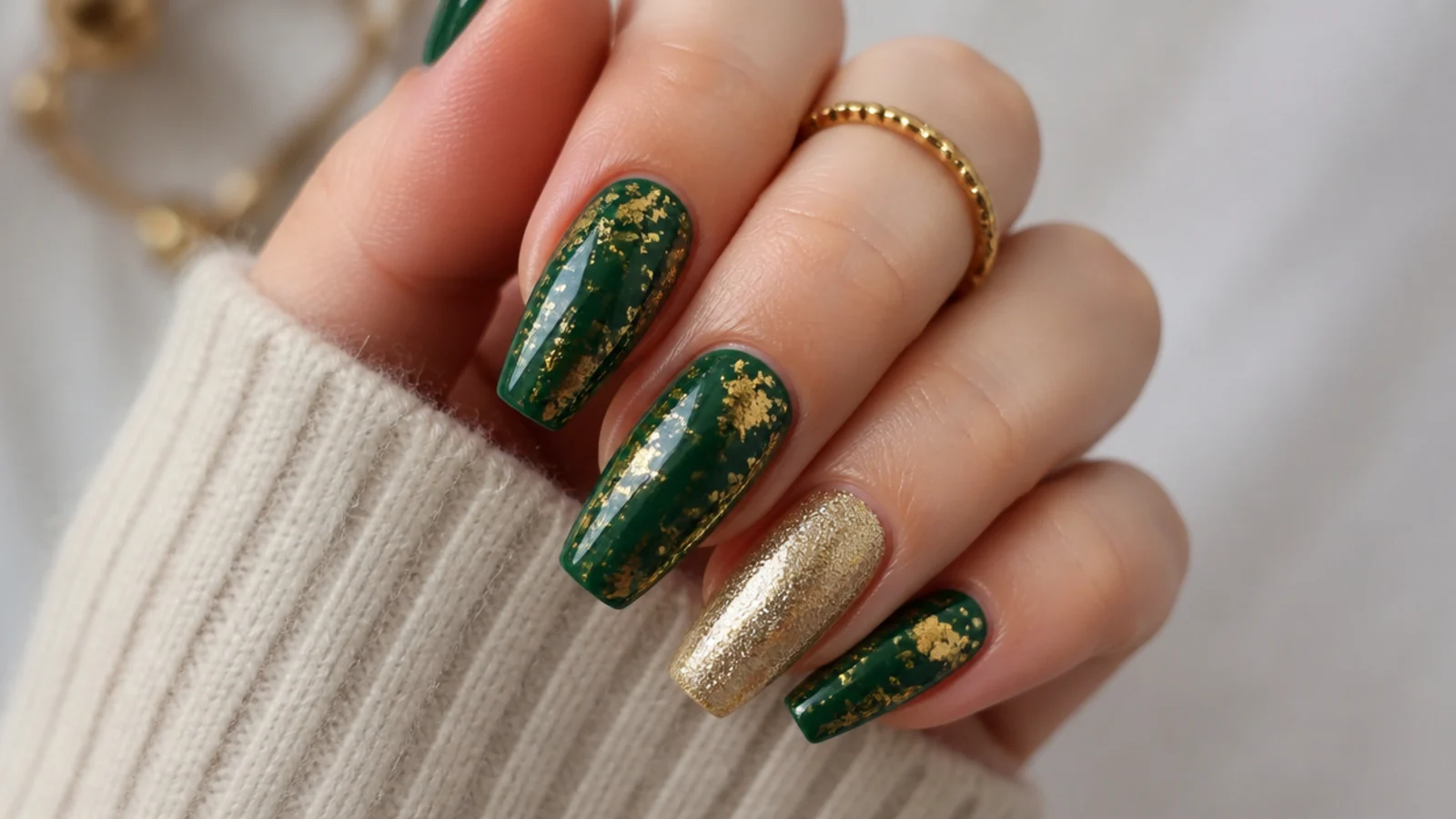 Coffin nails in dark emerald with gold foil flecks and a single gold accent nail