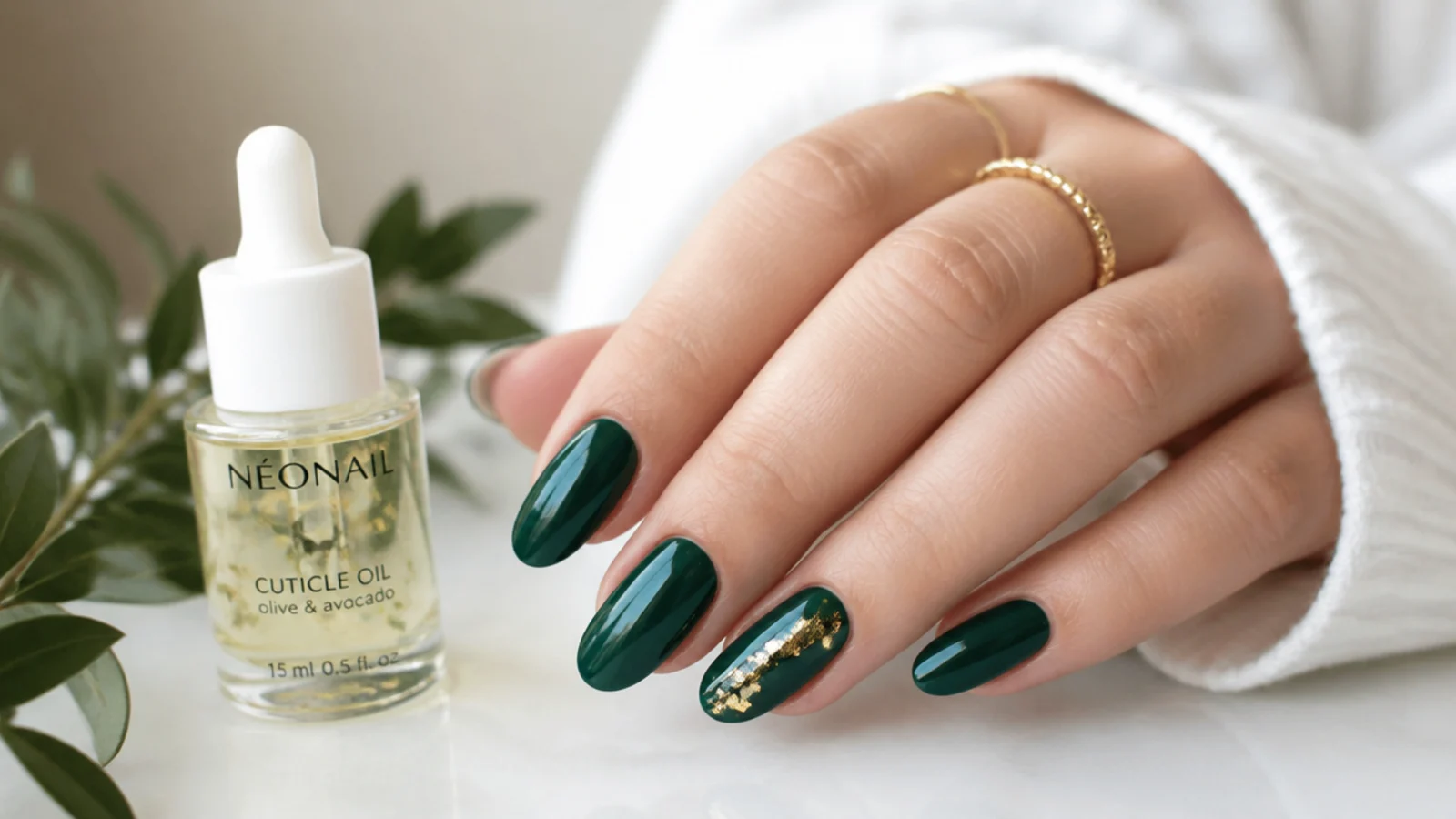 Cuticle oil beside a glossy dark emerald green gel manicure for longevity