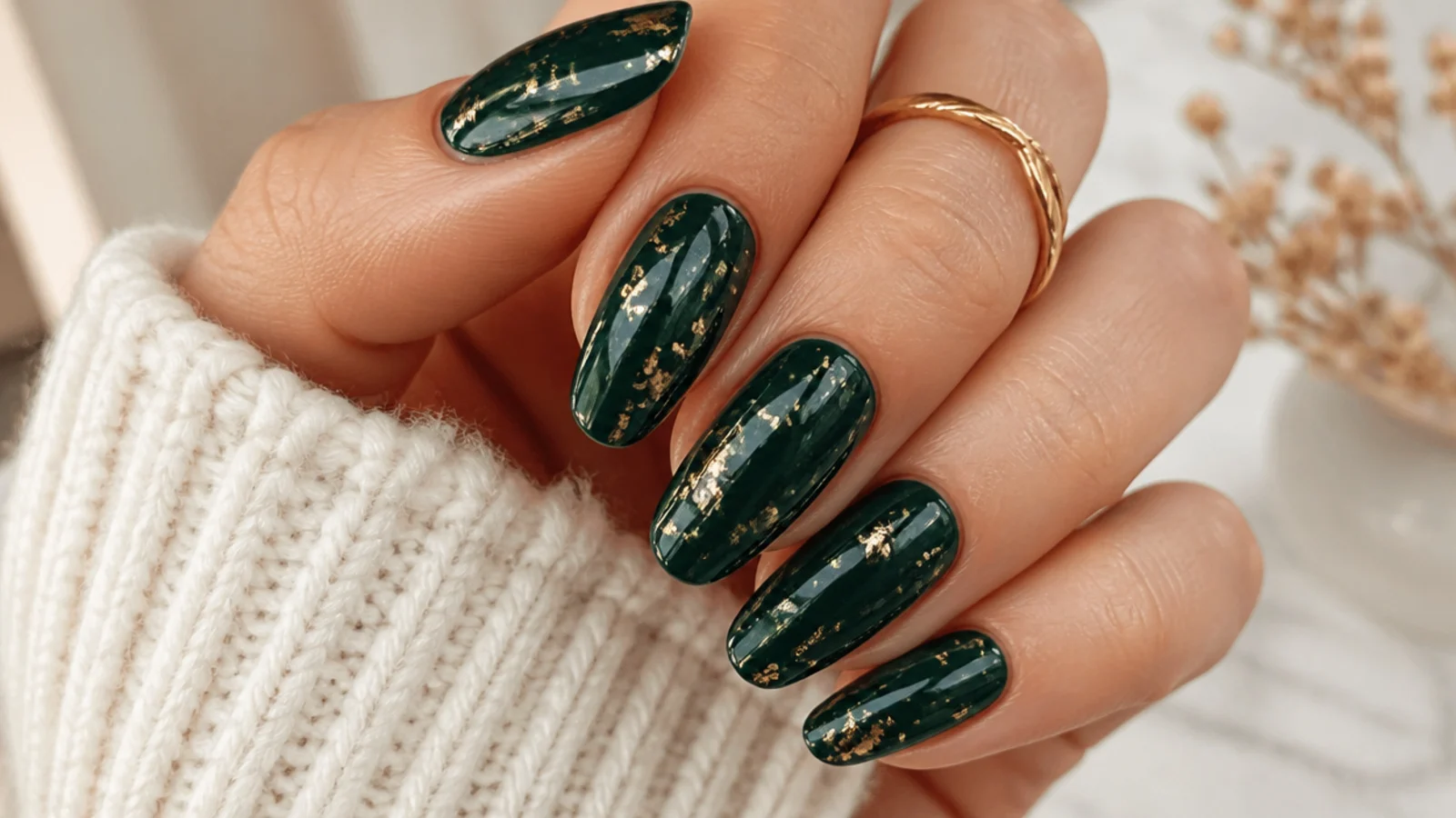 Deep emerald nails scattered with thin gold foil flakes