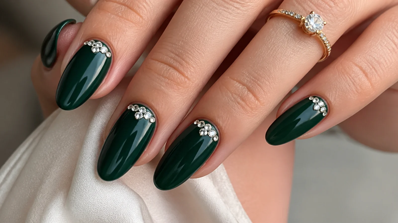 Deep emerald nails with a cluster of clear rhinestones near the cuticle
