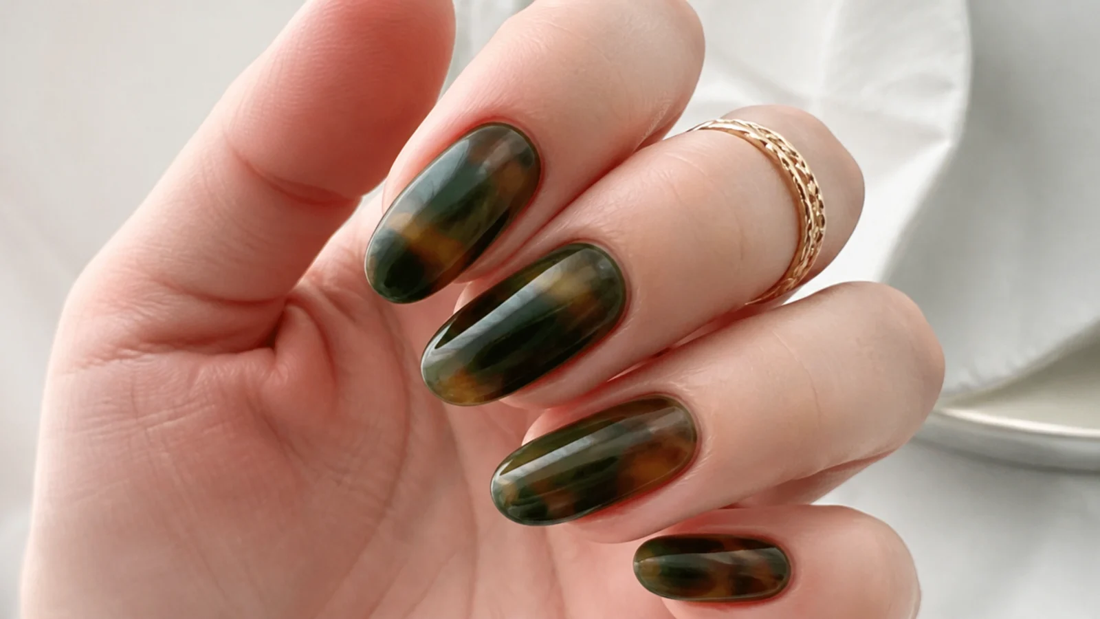 Deep green tortoiseshell nails with amber and brown mottling