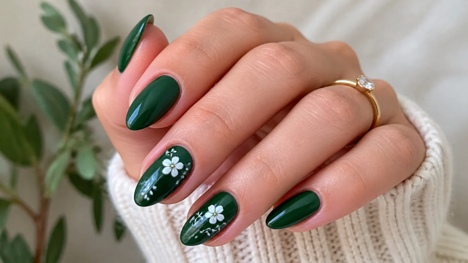 Deep green nails with delicate hand-painted white floral accents