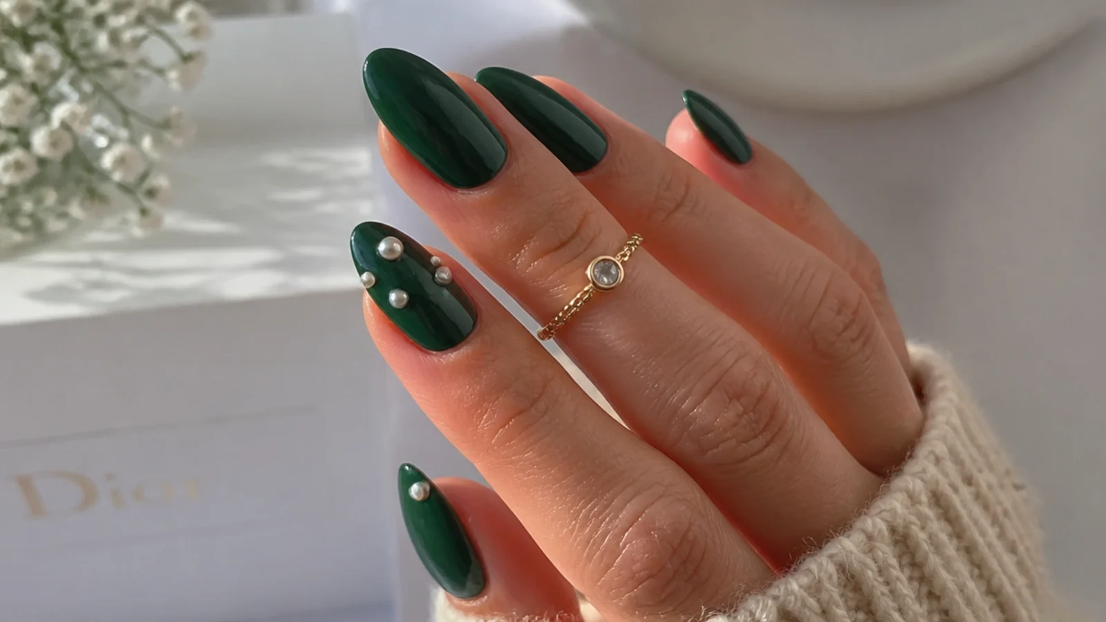 Deep green nails with small white pearls set on an accent nail