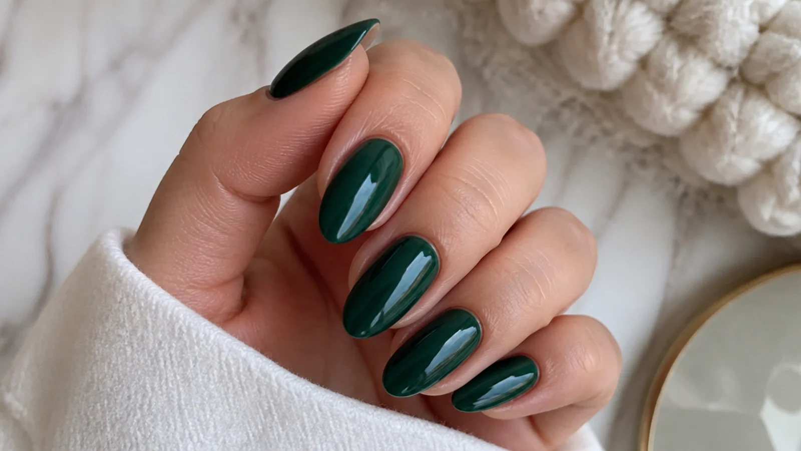 Deep emerald green gel nails in an almond shape with a glossy finish