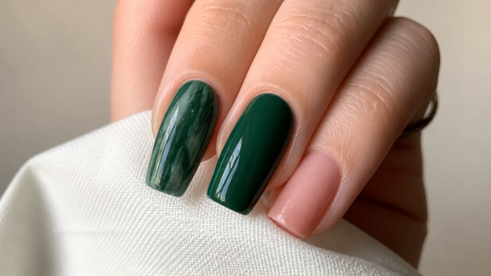 A streaky patchy dark green nail next to a smooth glossy one for comparison