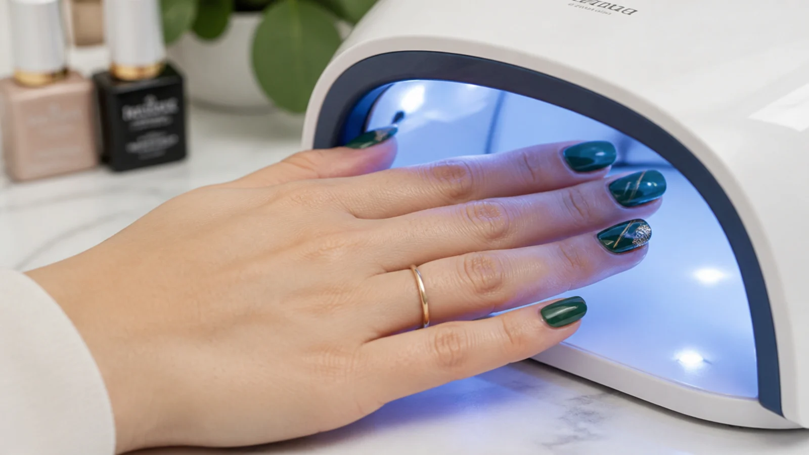 A glossy gel top coat sealing deep green nails under an LED lamp