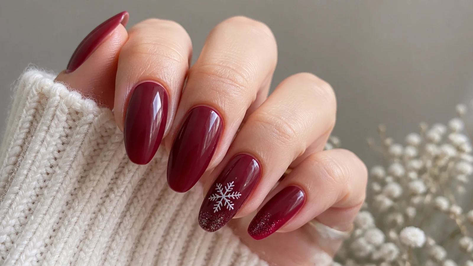 Deep cranberry red almond December nails with glossy finish