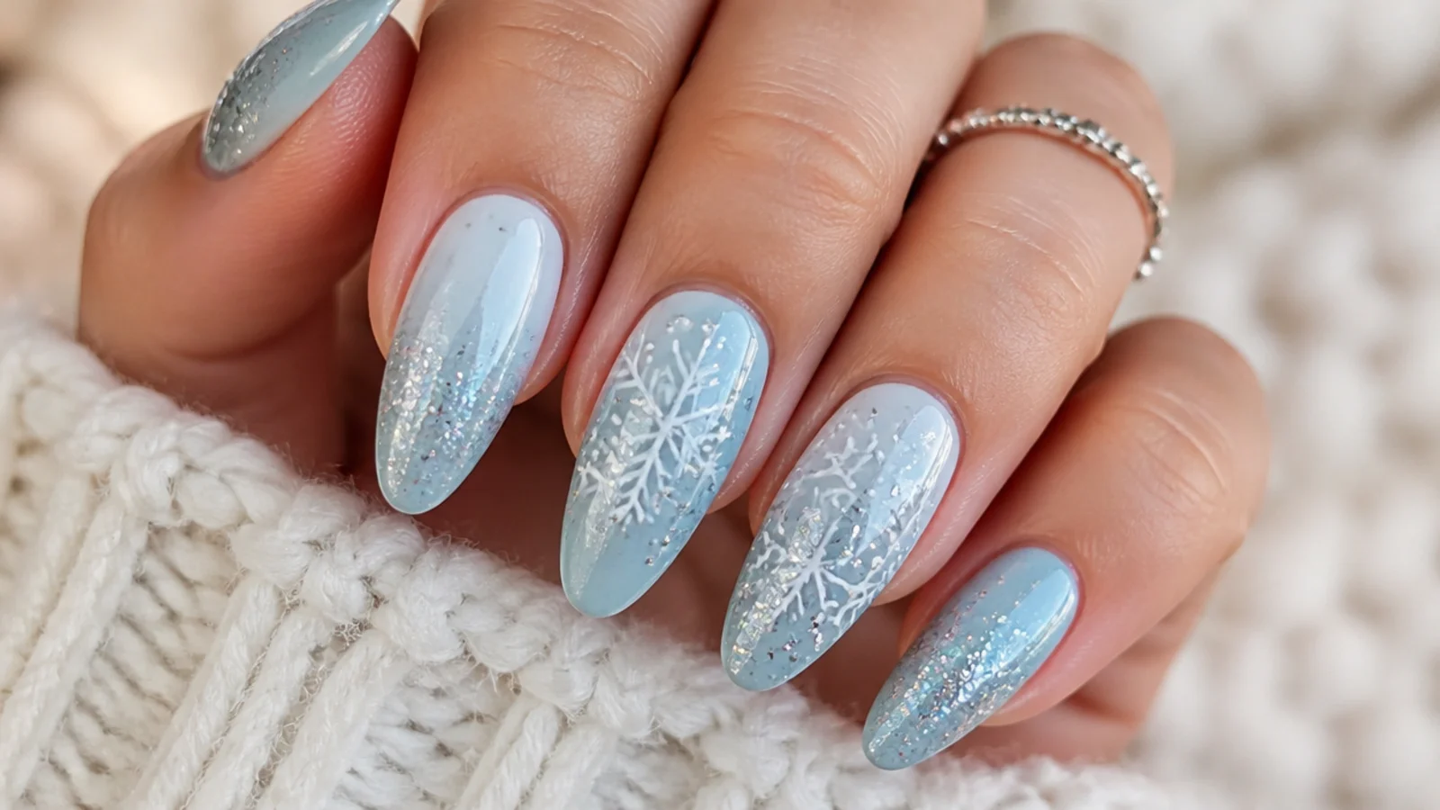 Icy blue almond December nails with white and silver snowflake details
