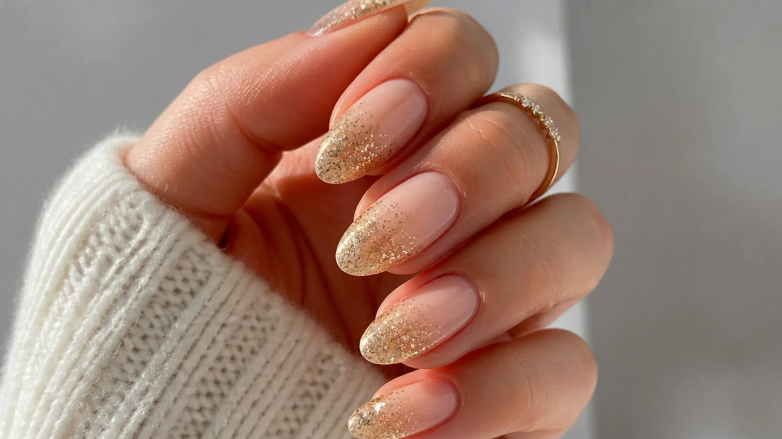 Nude to gold glitter ombre almond December nails for New Year