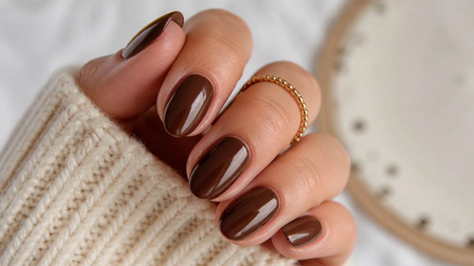 Short almond December nails in glossy chocolate brown