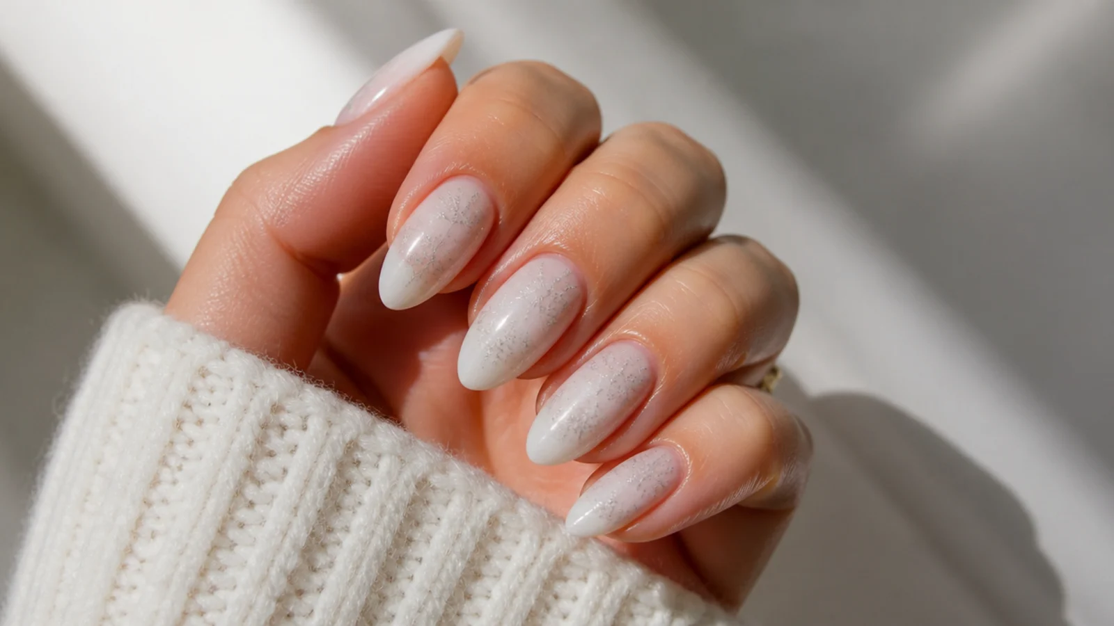 Milky white almond December nails with fine silver snowflake details