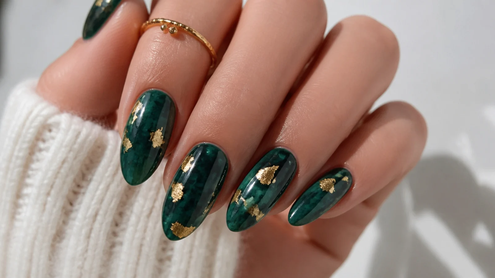 Rich emerald green December birthday nails with gold foil flecks