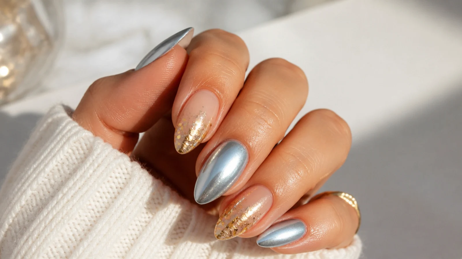 Icy blue chrome and gold glitter December birthday nails on an almond shape