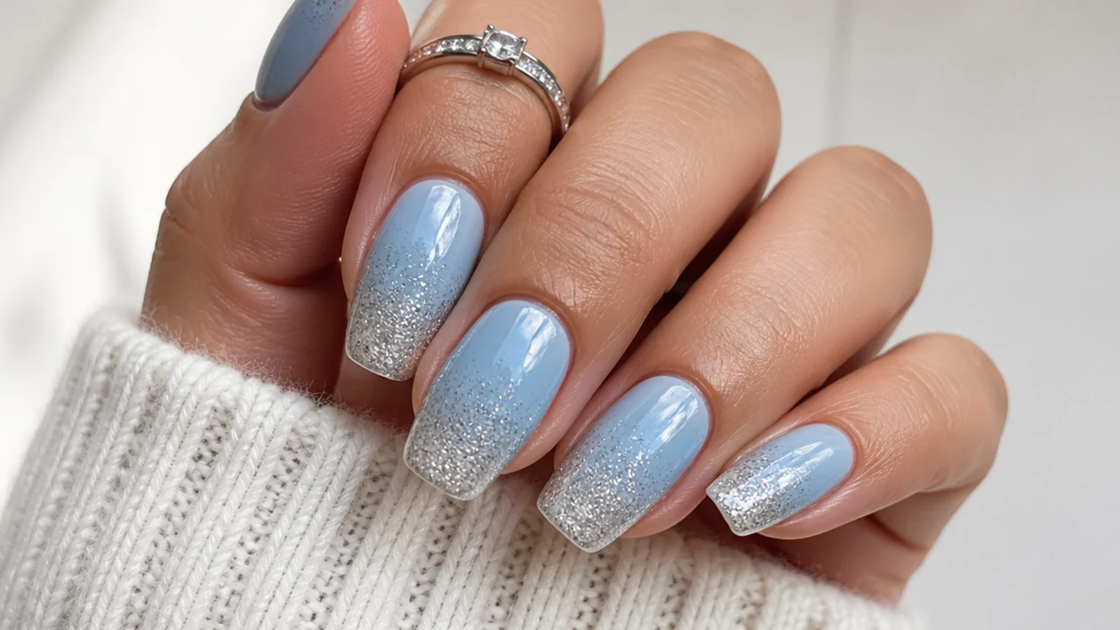 Icy blue fading into silver glitter ombre December nails