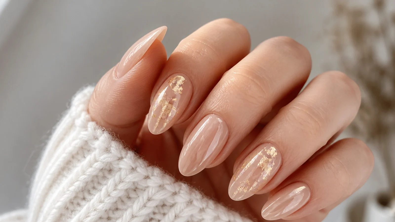 Champagne nude December nails with torn gold foil flakes on accent nails