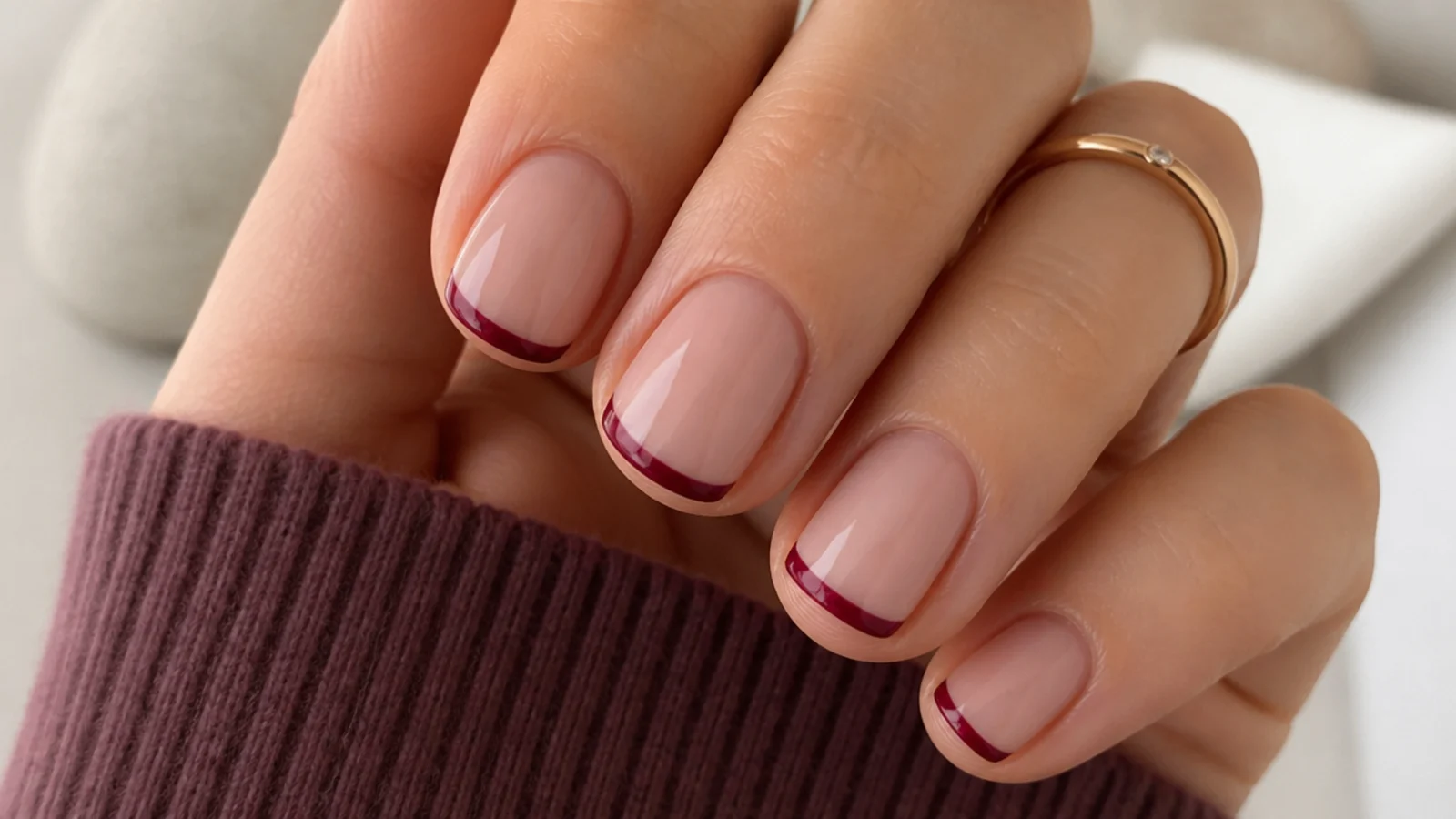 Short natural December nails with a thin cranberry micro-French tip