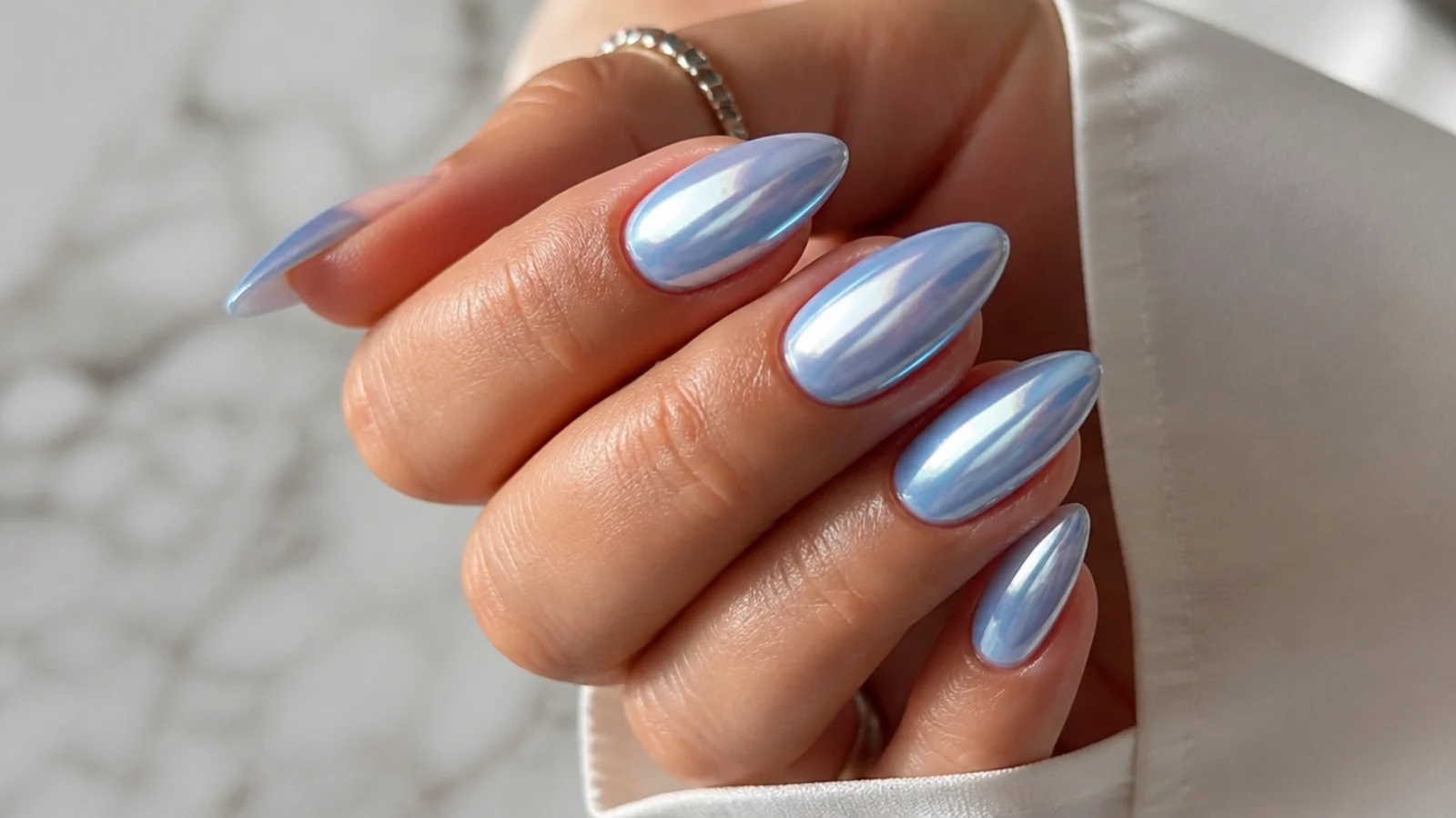 Almond nails in frosty pale blue with a mirror chrome powder finish