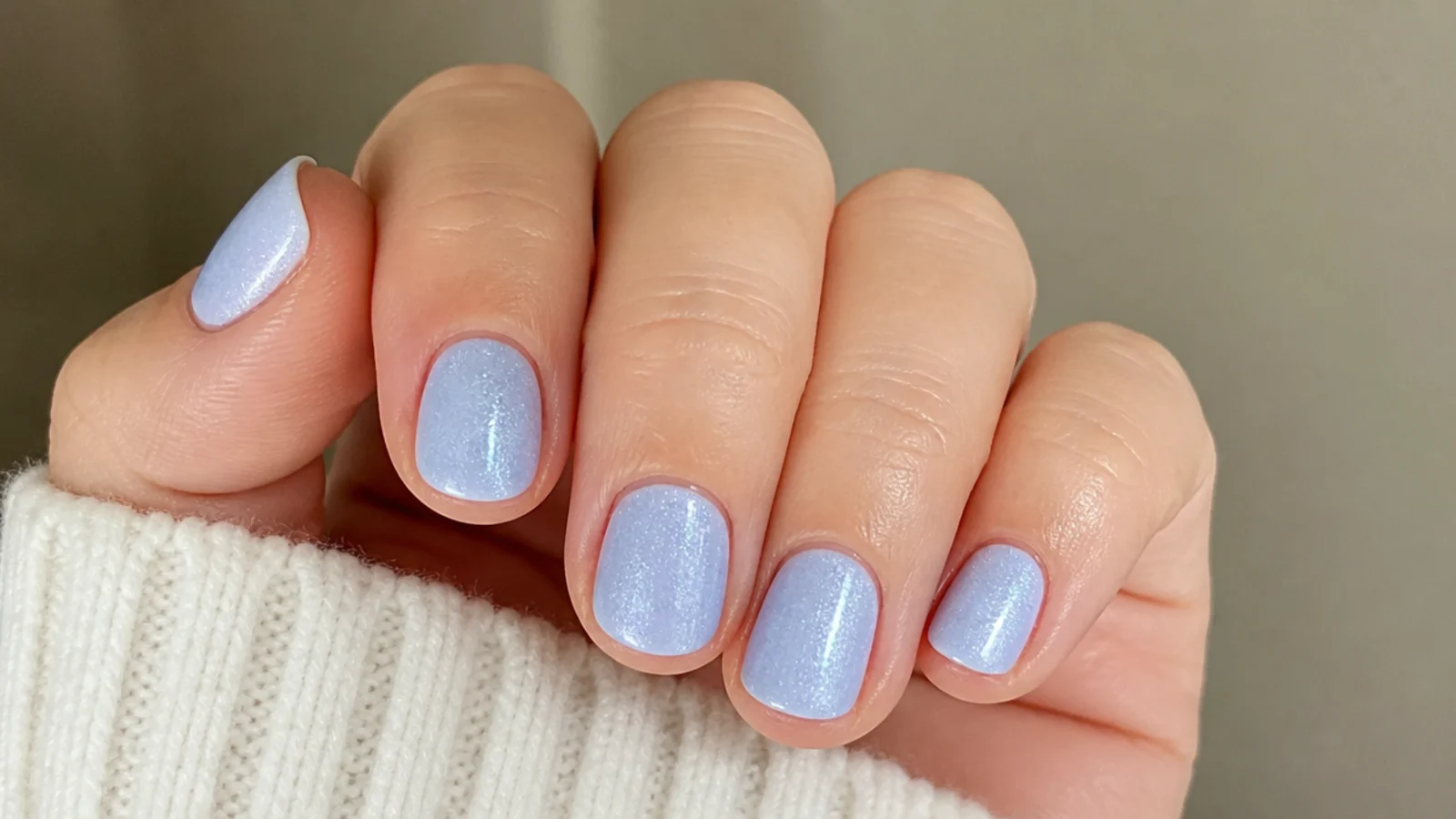 Short round nails in soft frosted baby blue with a subtle shimmer