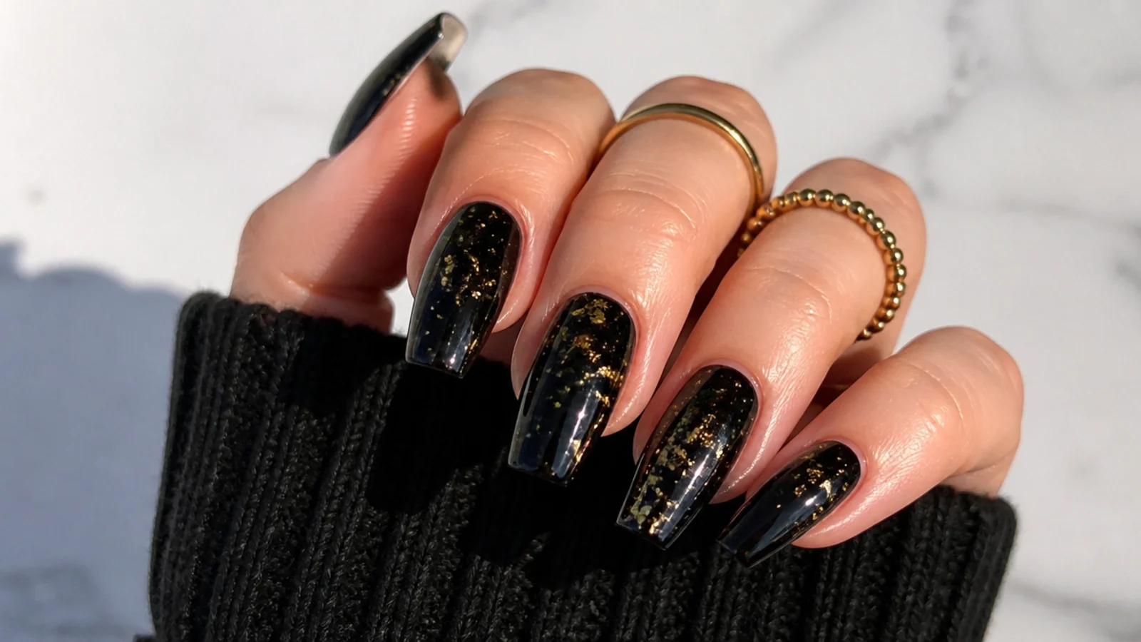 Coffin nails in glossy black with scattered gold flake confetti