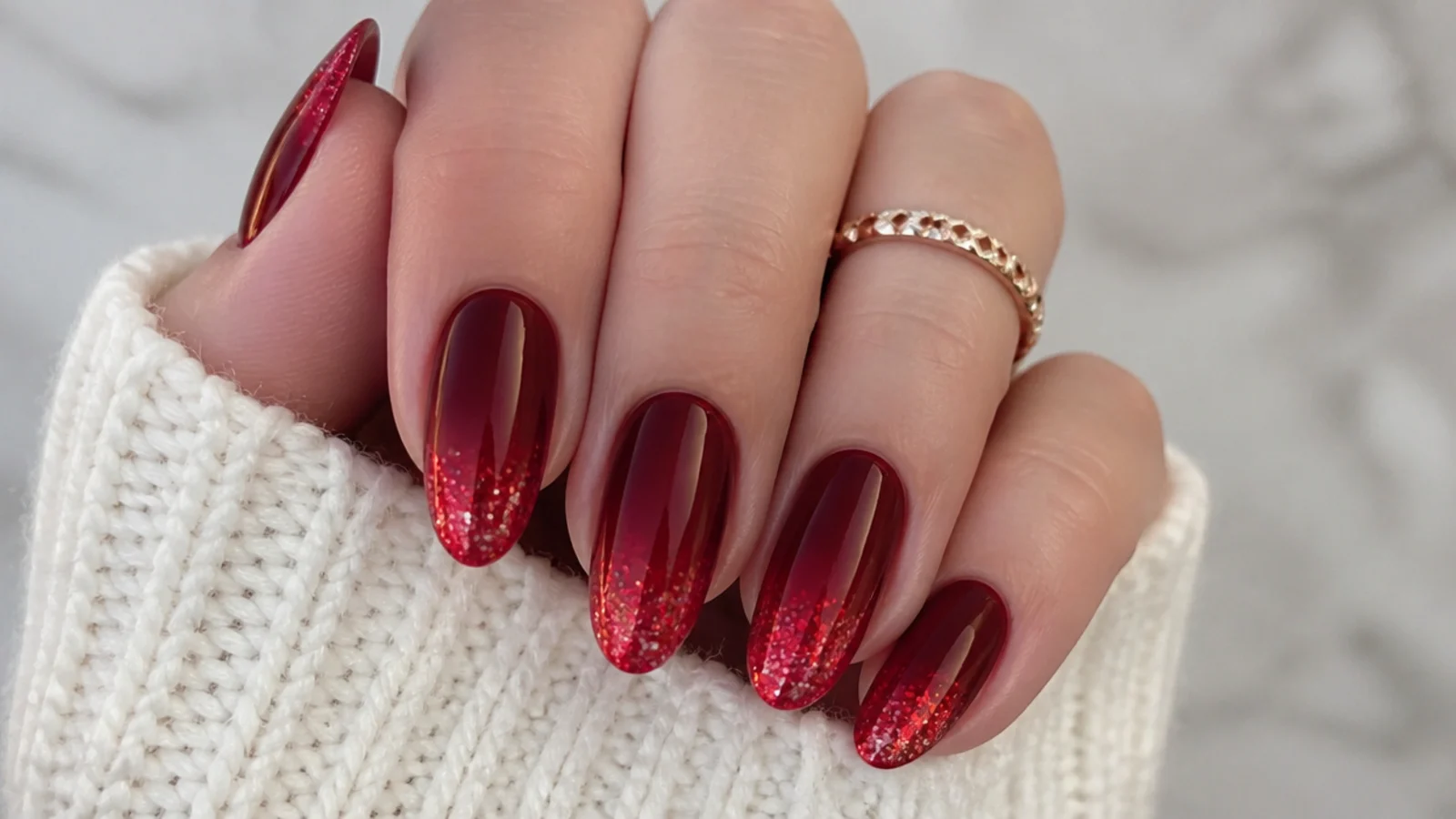 Deep red December nails fading into red glitter tips in an ombre