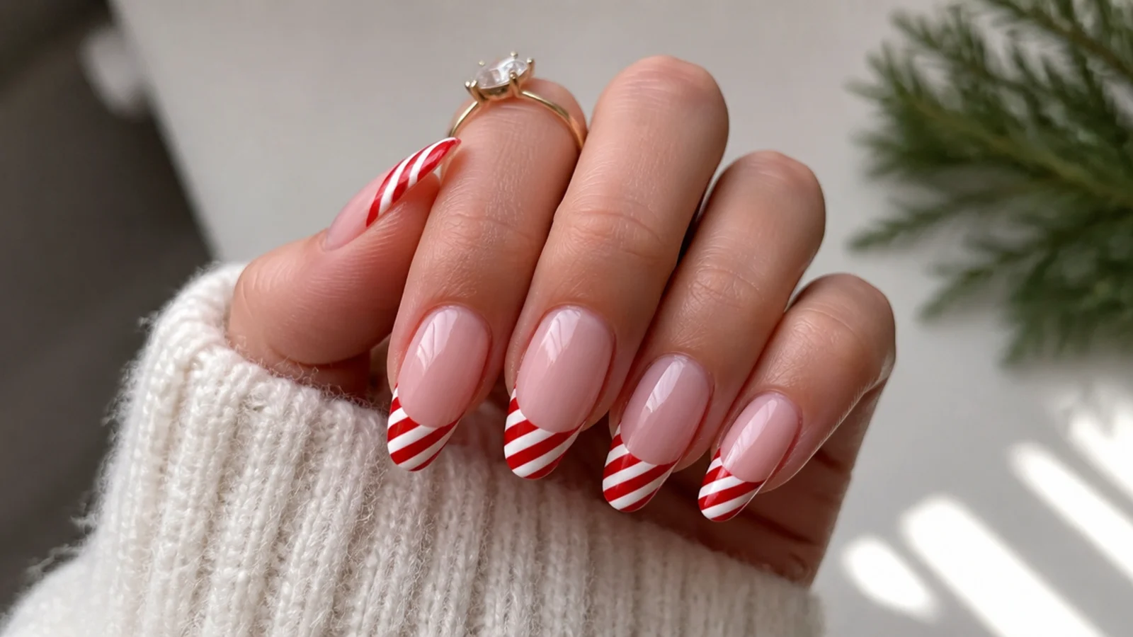 Red and white candy cane striped French tip December nails on almond shape