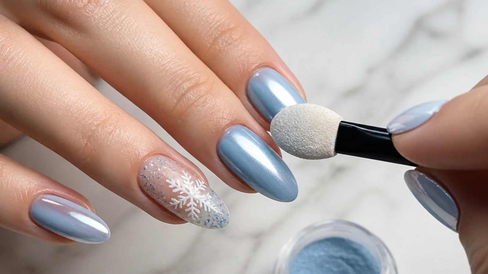 Blue-silver chrome powder being buffed into a cured top coat for an icy December nail