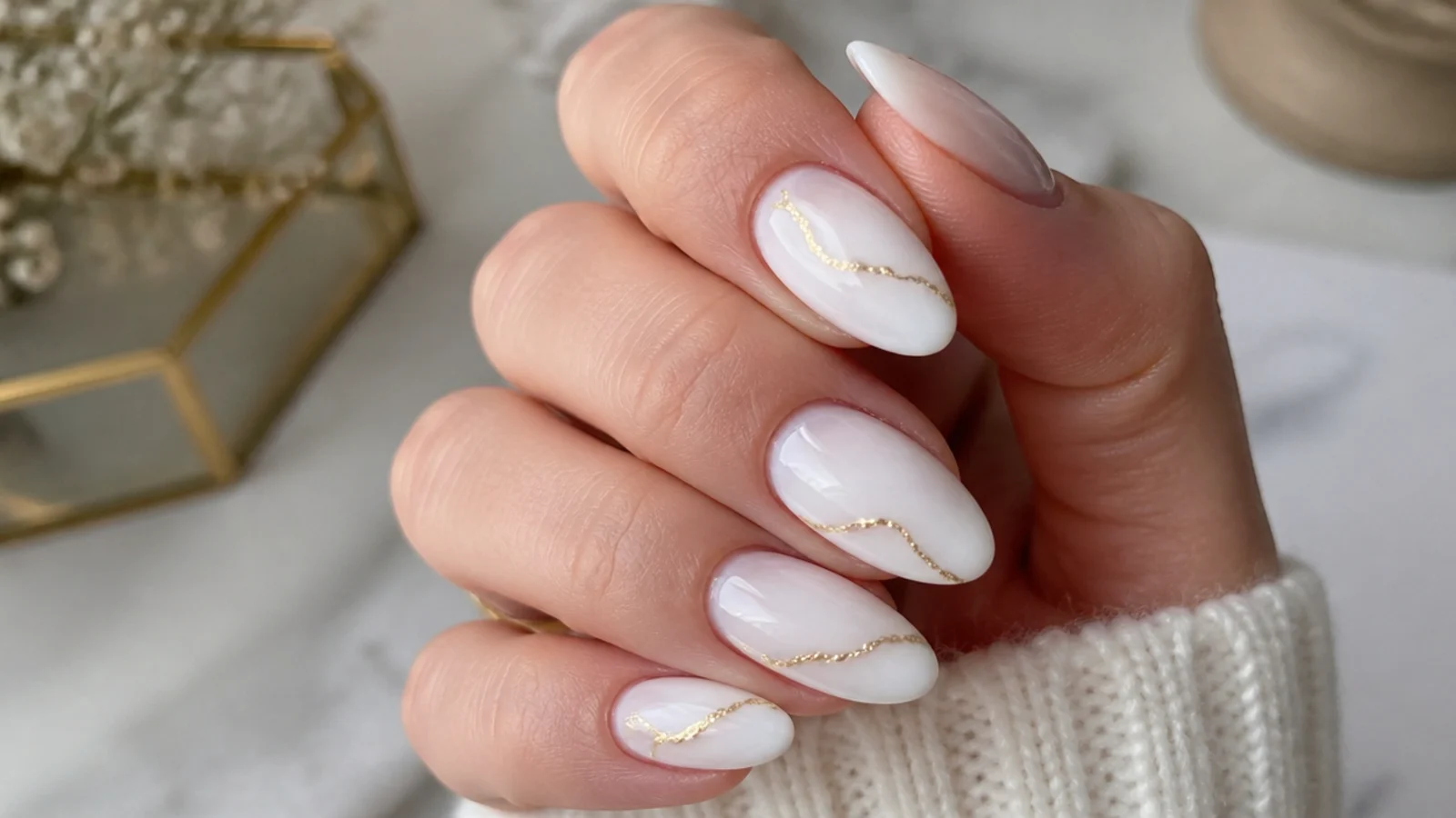 Milky white December nails with fine gold foil line accents