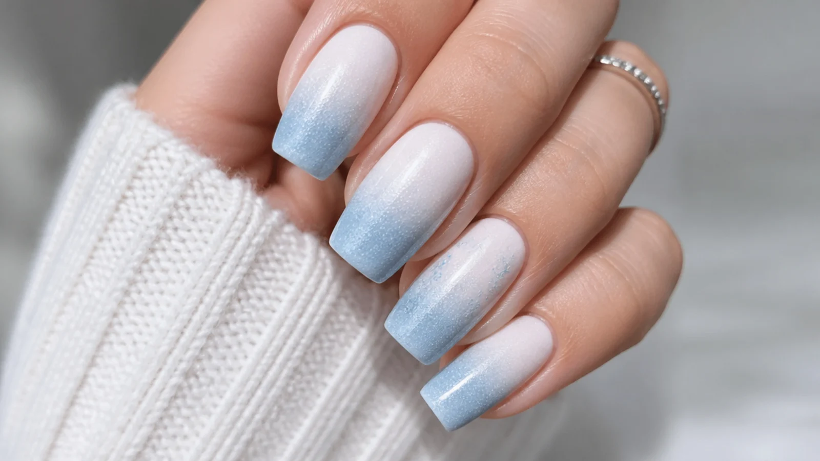 White to icy blue ombre December nails with a frosted finish