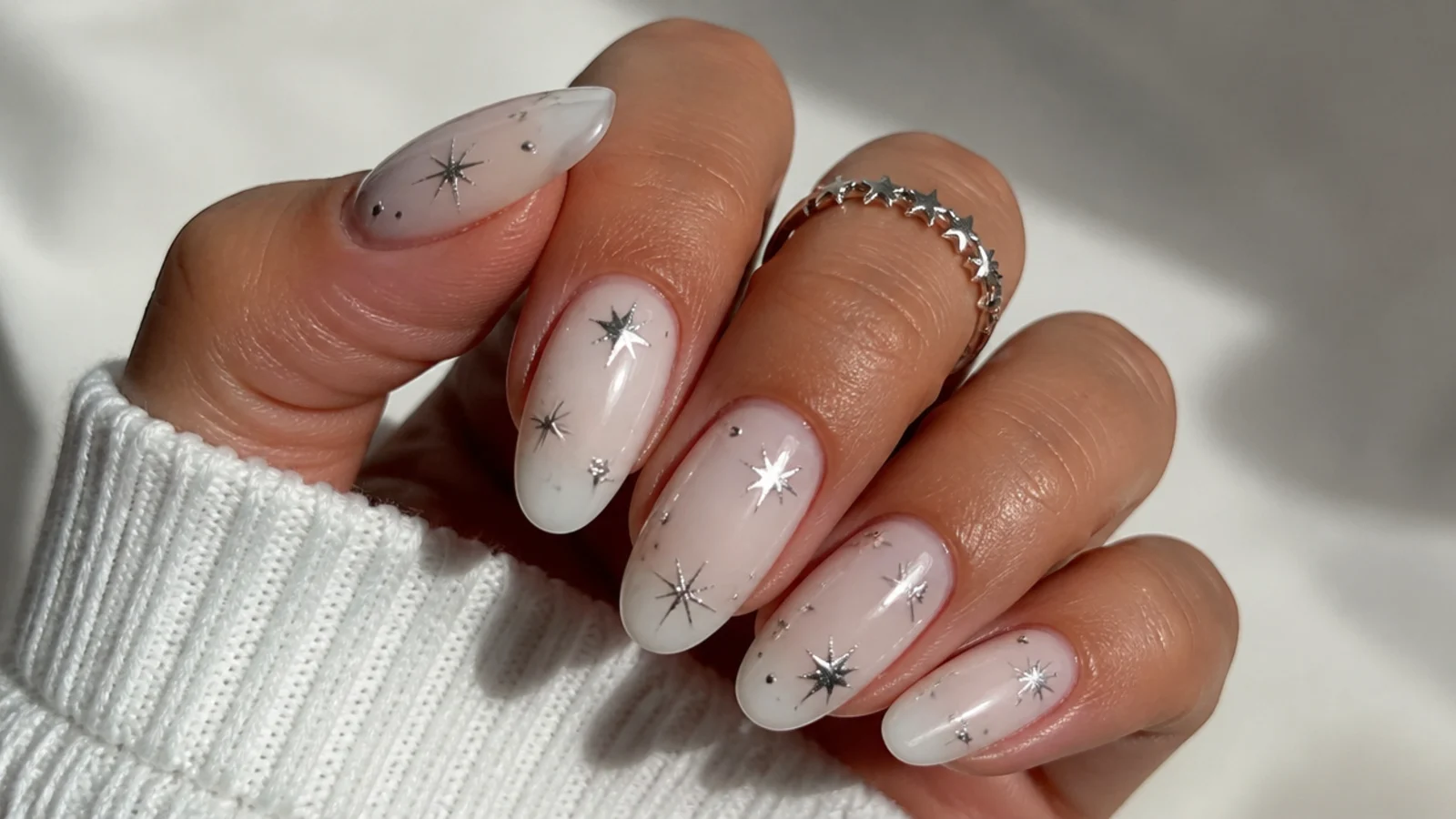 Milky white December nails with small silver stars and dots