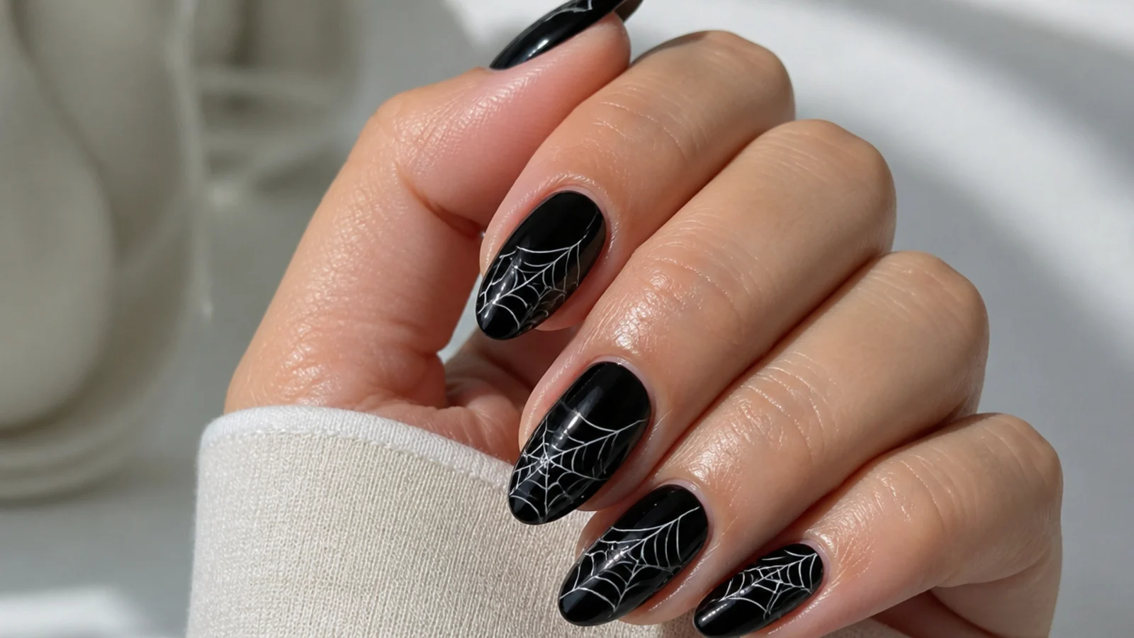 Black nails with fine white spiderweb detail radiating from the corner
