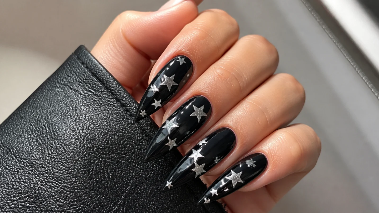 Glossy black emo nails with small white and silver five-point stars