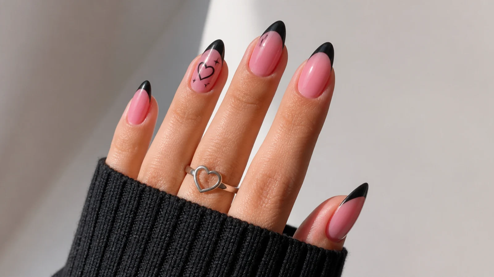 Pink emo nails with black French tips on an almond shape