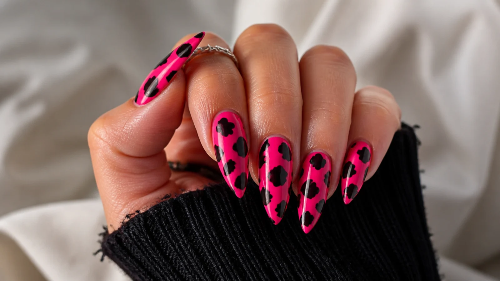 Hot pink emo nails with black cow-print splotches