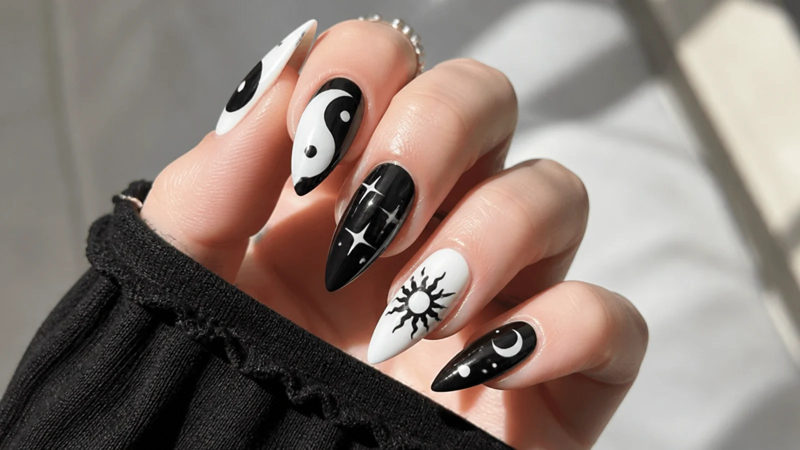 Black and white yin-yang emo nails with small accent symbols