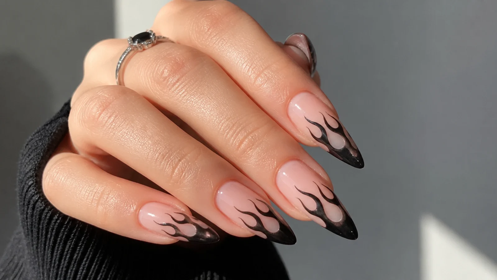 Nude emo nails with black flame tips licking up from the edge