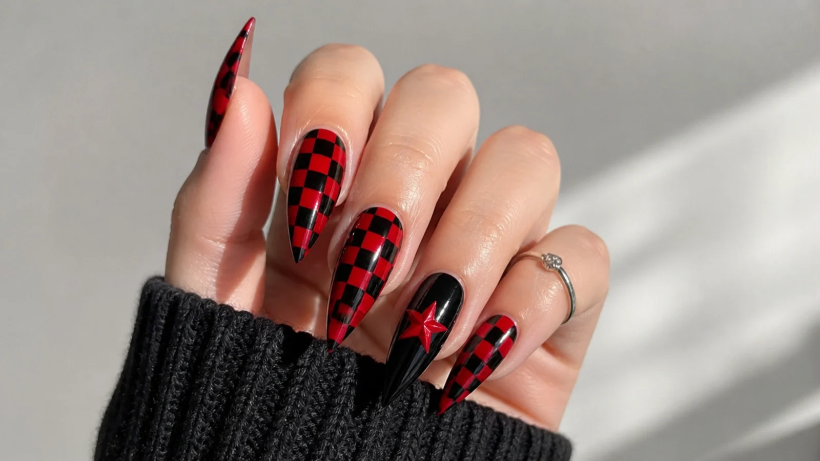 Deep red and black checkerboard emo nails on a stiletto shape